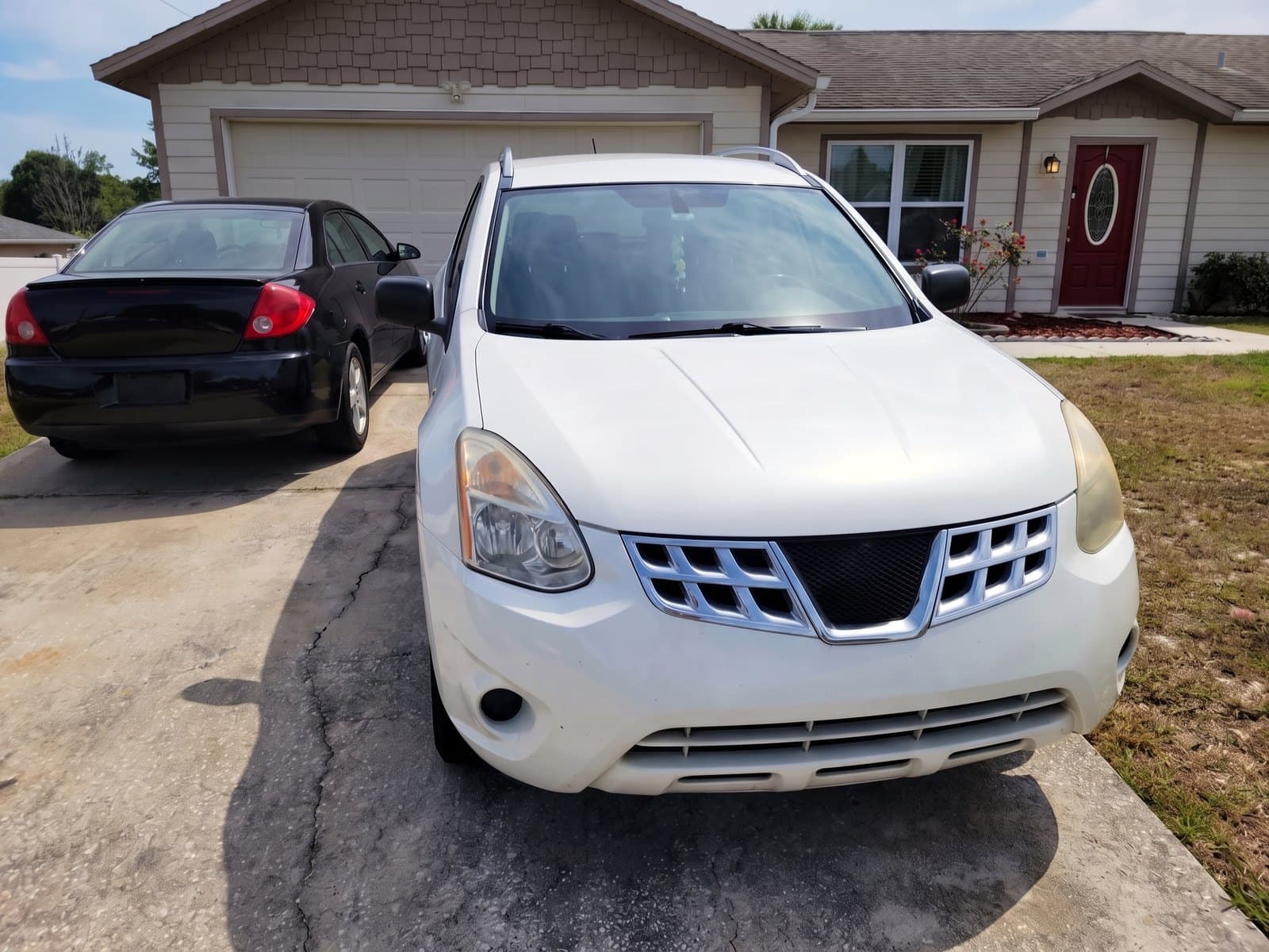 A white compact SUV in a driveway in Deltona, FL, after a Bang AutoGlass mobile glass job