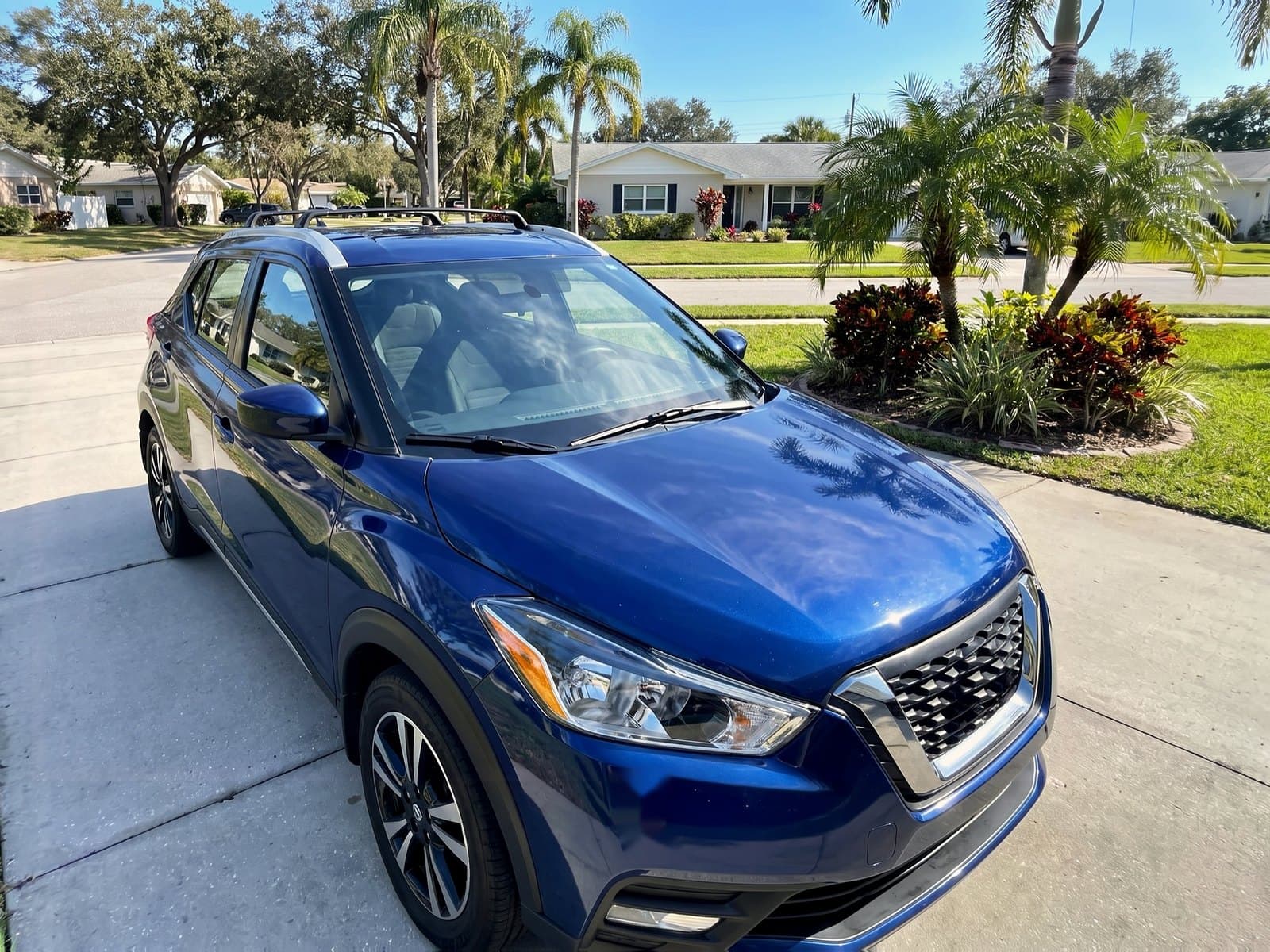 A blue compact SUV with roof rails in a driveway in Dunedin, FL, after a Bang AutoGlass mobile glass job