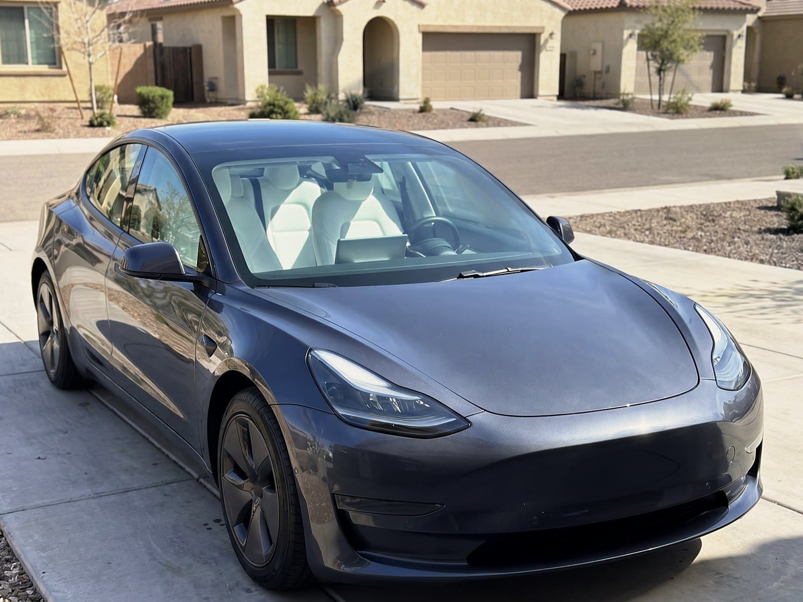 A grey sedan in a driveway in Gilbert, AZ, after a Bang AutoGlass mobile glass job