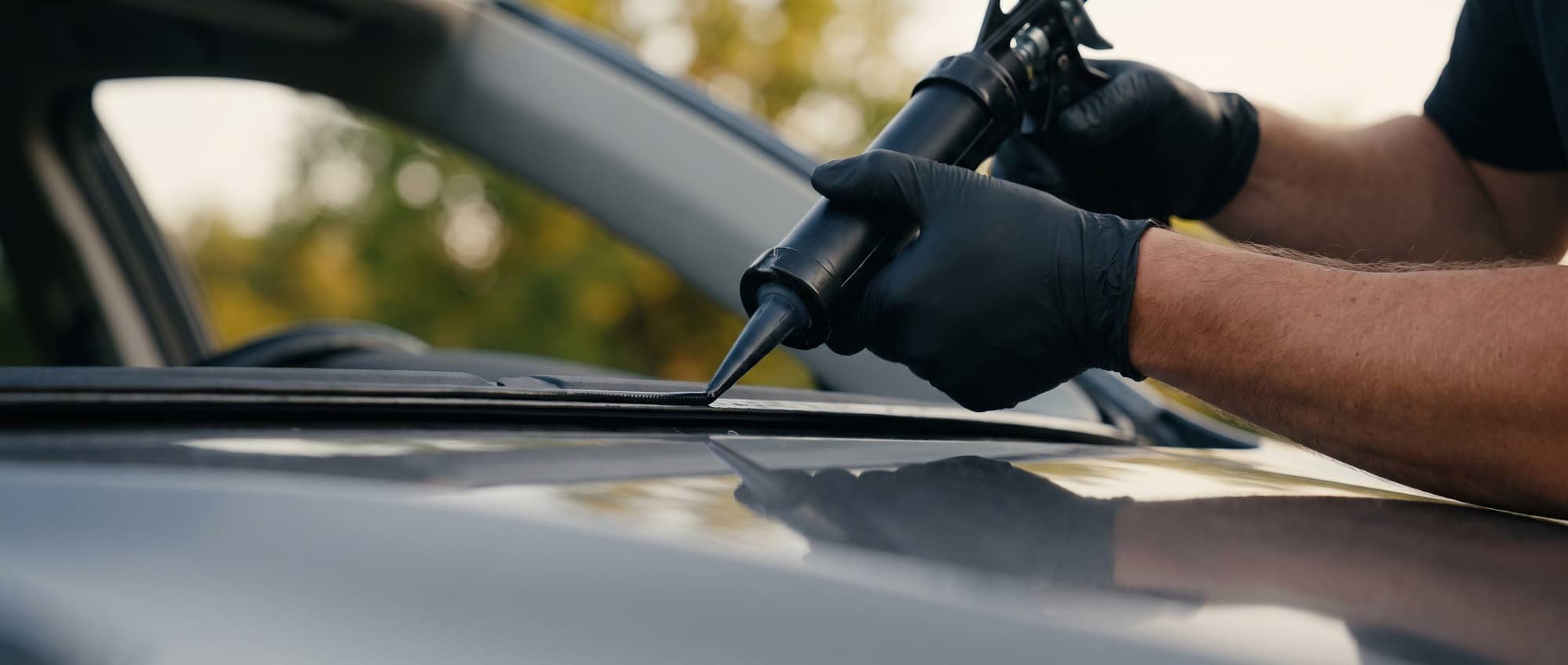 Bang AutoGlass technician setting a new windshield with suction-cup handles — OEM-quality glass backed by a lifetime workmanship warranty